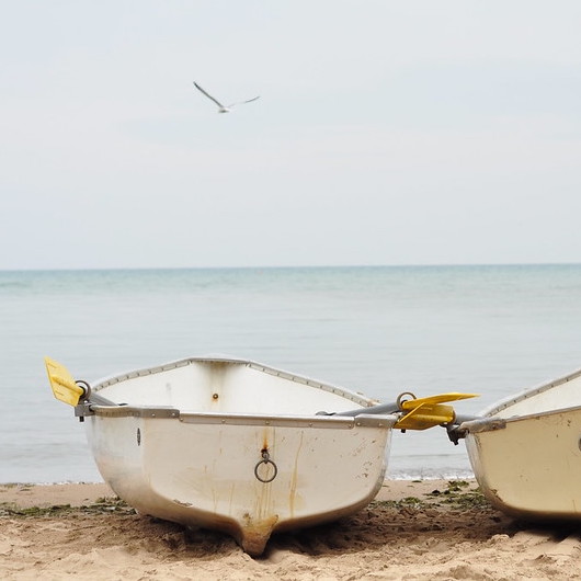 two boats next to each other on the beach